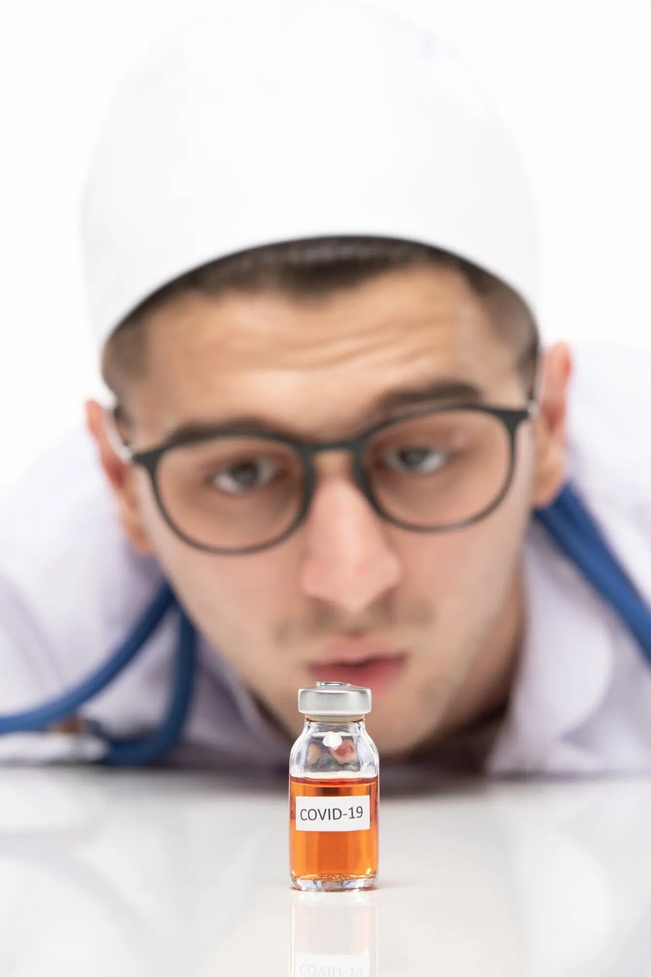Вид спереди: мужчина-врач в медицинском костюме с вакциной.